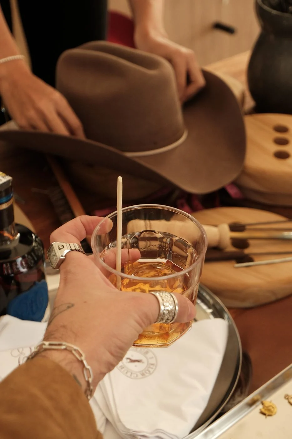 Hat Tender ELÓR ajustando un sombrero en el atelier de Medellín
